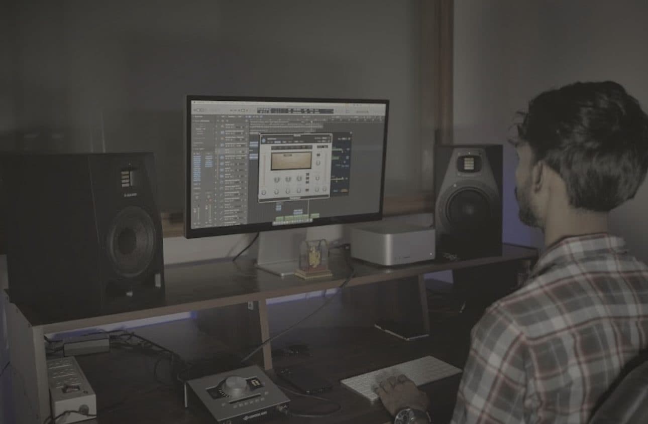 An engineer working a session in Logic Pro at the desk