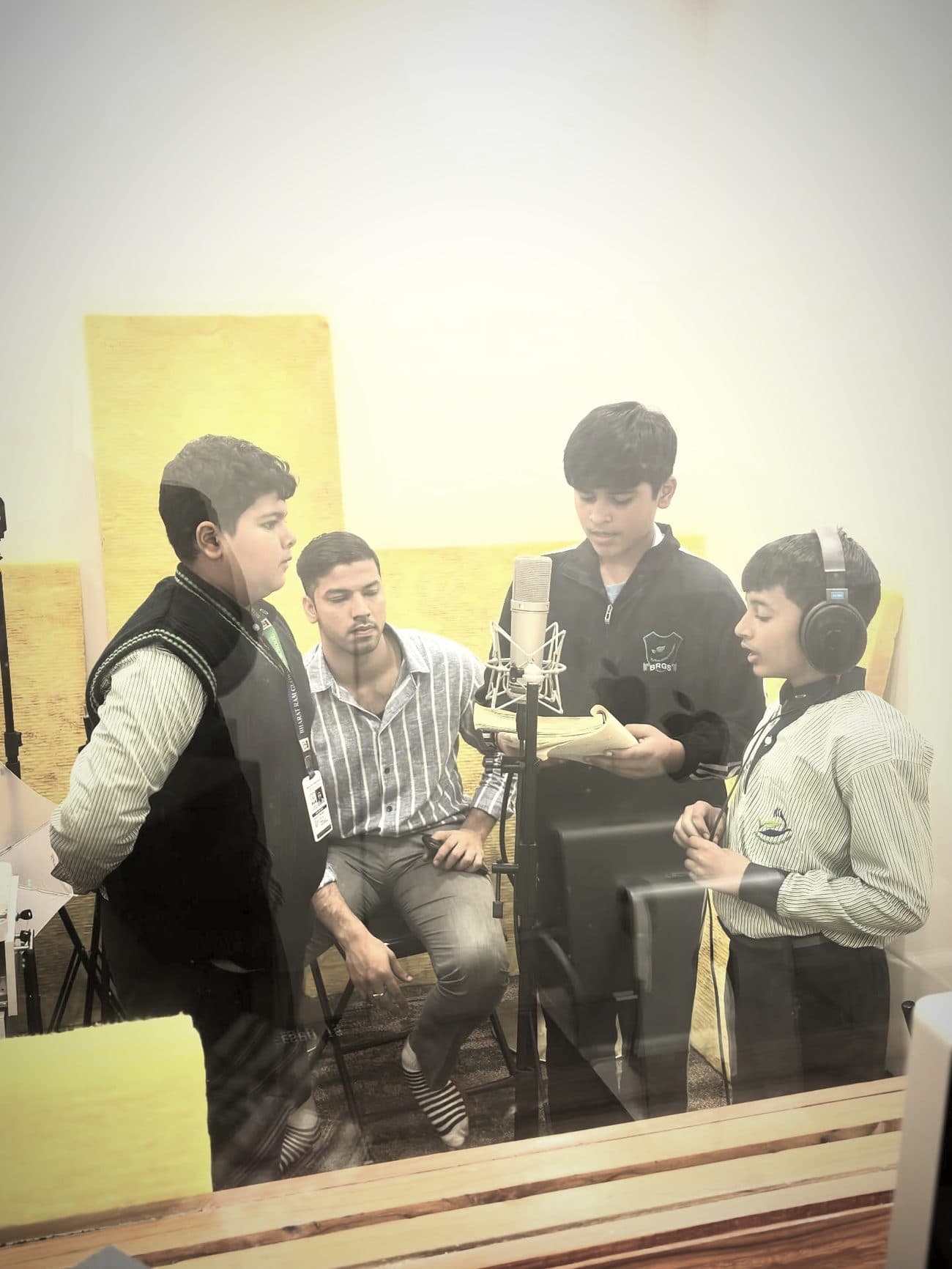 Four singers gathered around a single microphone